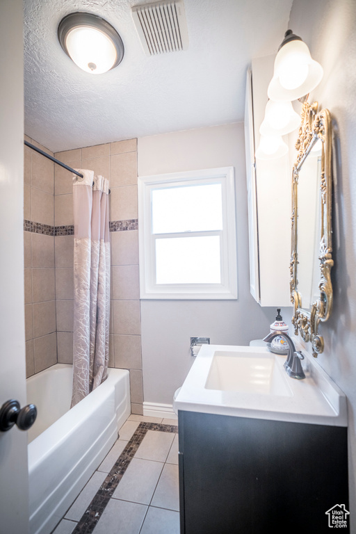 Bathroom featuring shower / tub combo with curtain, vanity, tile flooring, and a textured ceiling