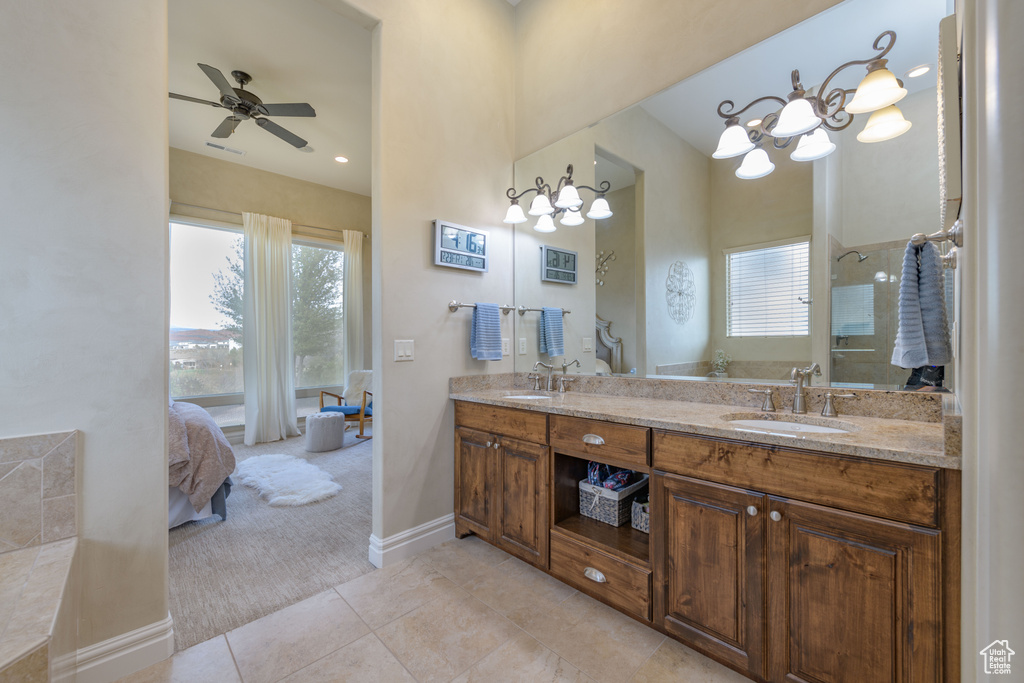 Bathroom featuring vanity with extensive cabinet space, tile floors, double sink, and ceiling fan