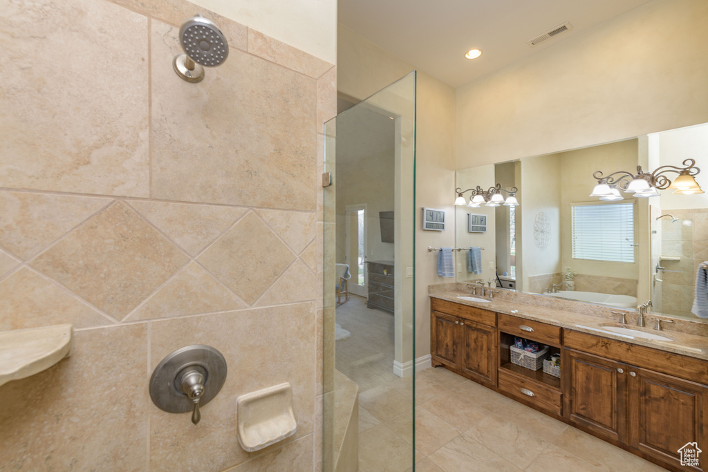 Bathroom with dual bowl vanity, tile walls, tile flooring, and separate shower and tub