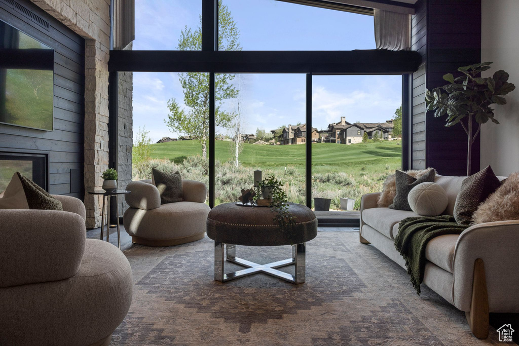 Living area featuring golf course view, healthy amount of natural light, and expansive windows