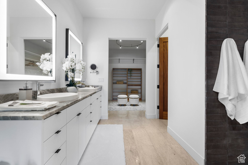 Full bathroom with double vanity and baseboards
