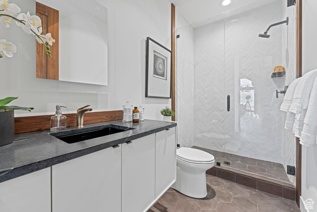 Full bathroom featuring toilet, vanity, recessed lighting, and a shower stall