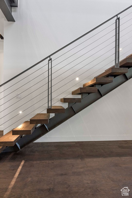 Staircase with wood finished floors and baseboards