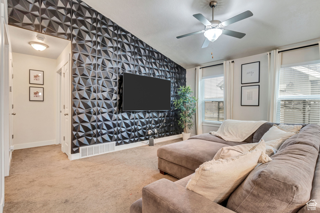 Carpeted living room with ceiling fan and lofted ceiling