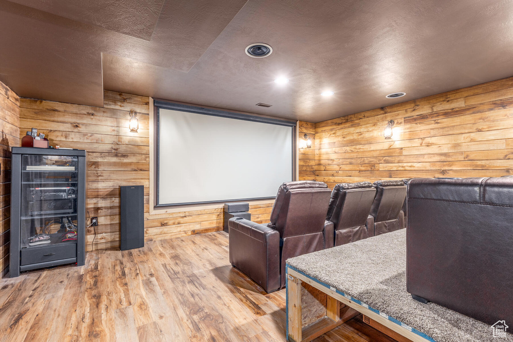 Cinema featuring light hardwood / wood-style flooring and wood walls