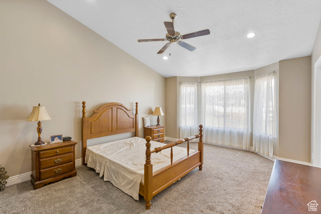 Bedroom featuring carpet floors, ceiling fan, a textured ceiling, and lofted ceiling