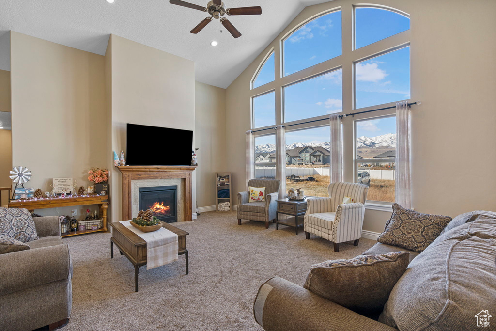 Living room featuring light carpet, ceiling fan, and high vaulted ceiling