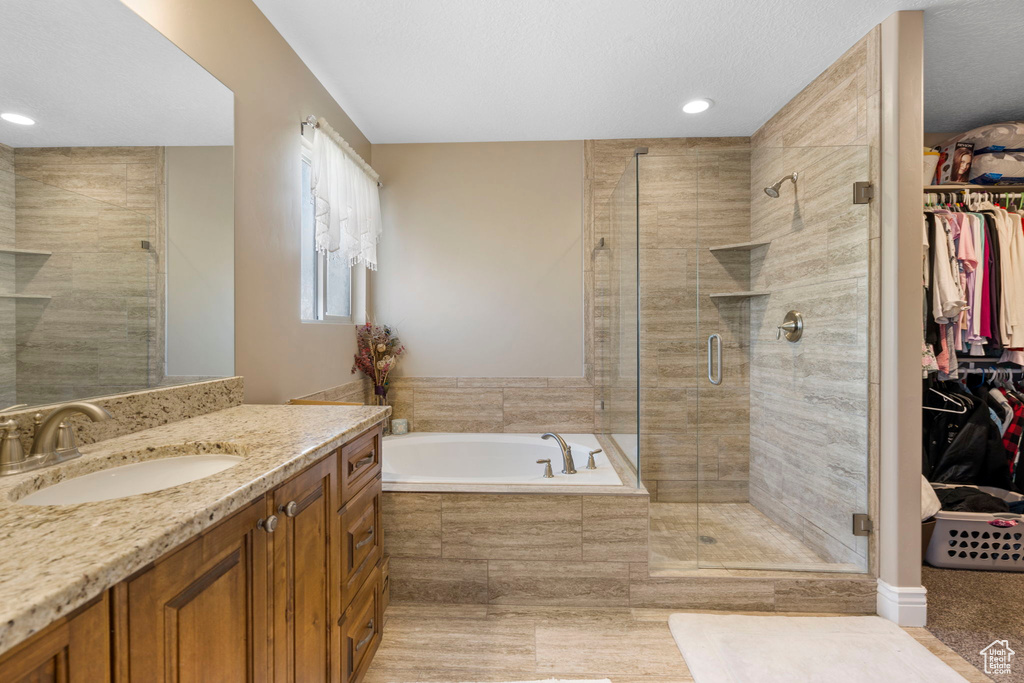 Bathroom with vanity with extensive cabinet space and plus walk in shower