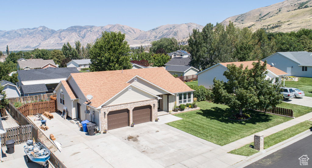 Exterior space featuring a front lawn, a garage, and a mountain view