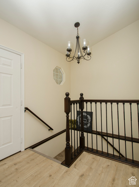 Stairway featuring a notable chandelier and light hardwood / wood-style floors