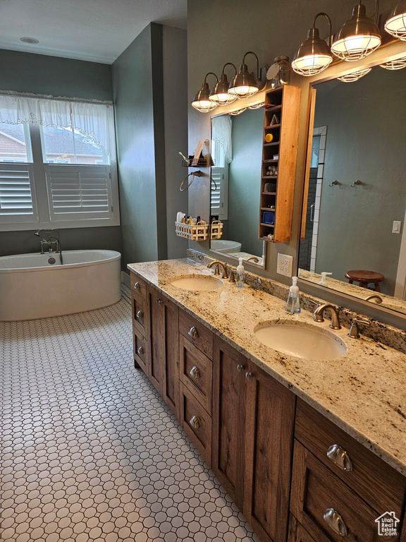 Bathroom with a bath to relax in, tile floors, and dual bowl vanity