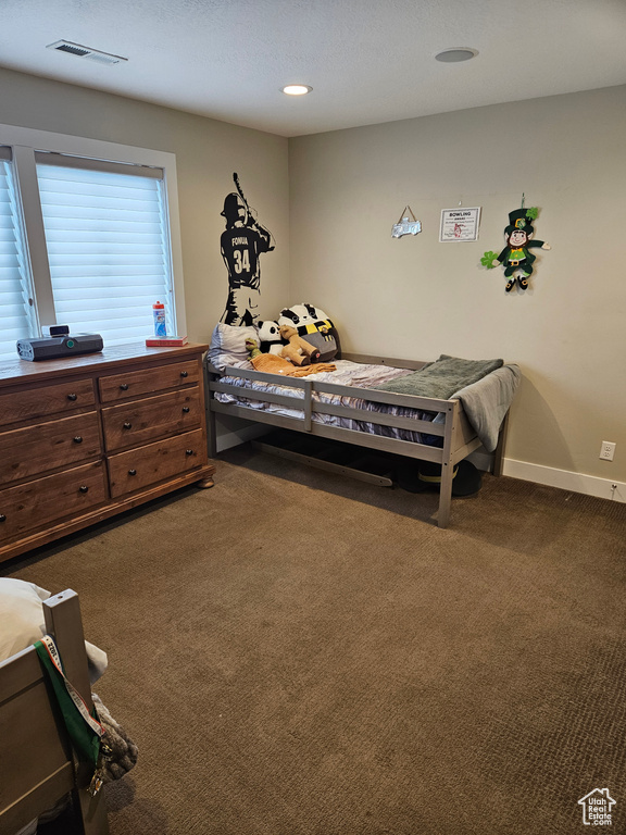 Bedroom with dark colored carpet