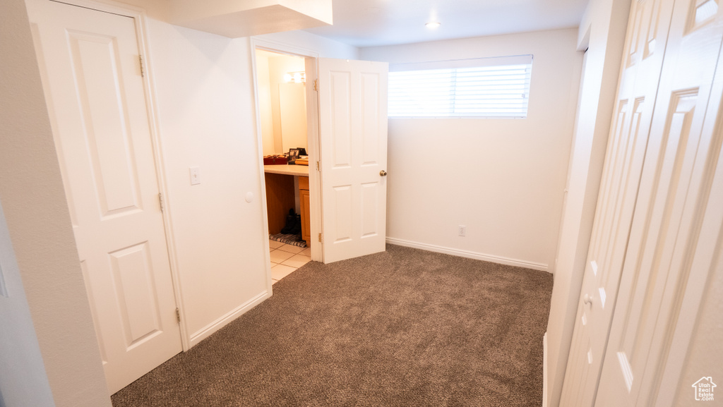Unfurnished bedroom featuring ensuite bath and light colored carpet