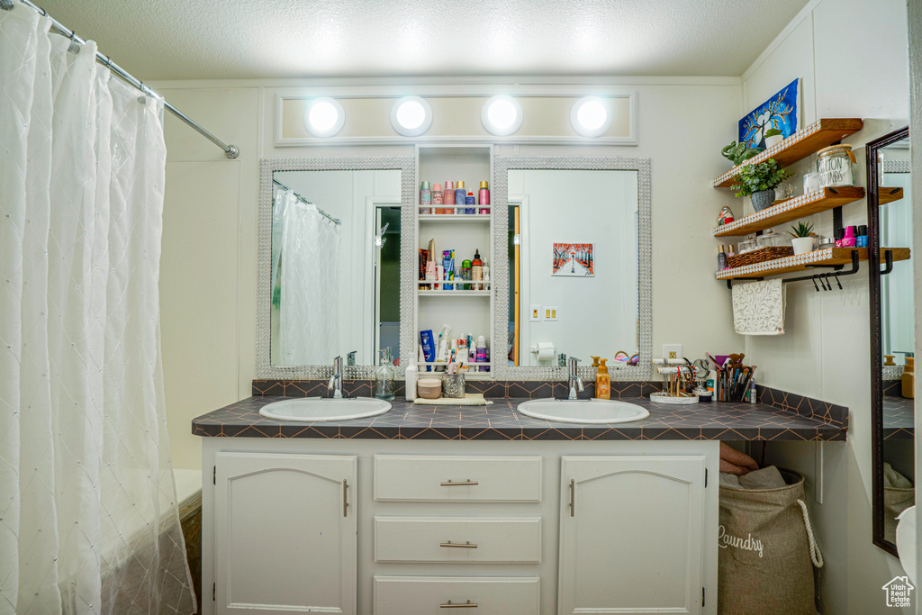 Bathroom with dual vanity and a textured ceiling