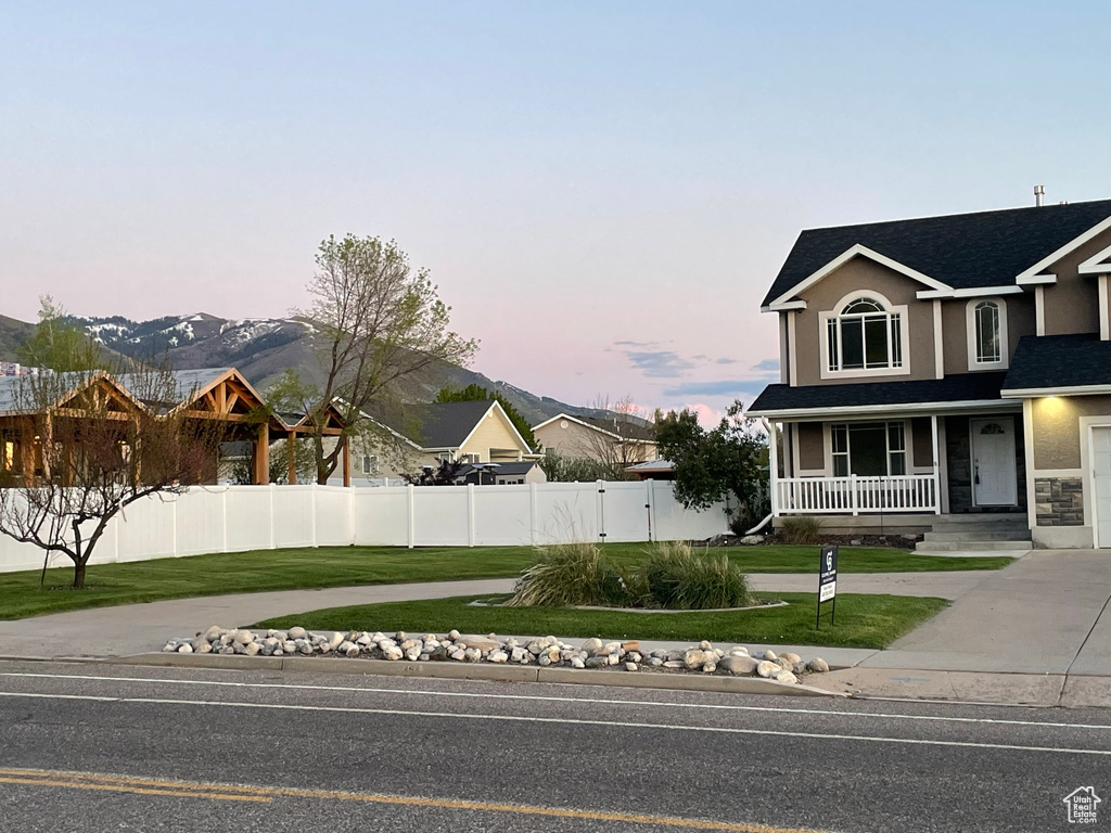 View of front facade featuring a yard, a mountain view, and a porch