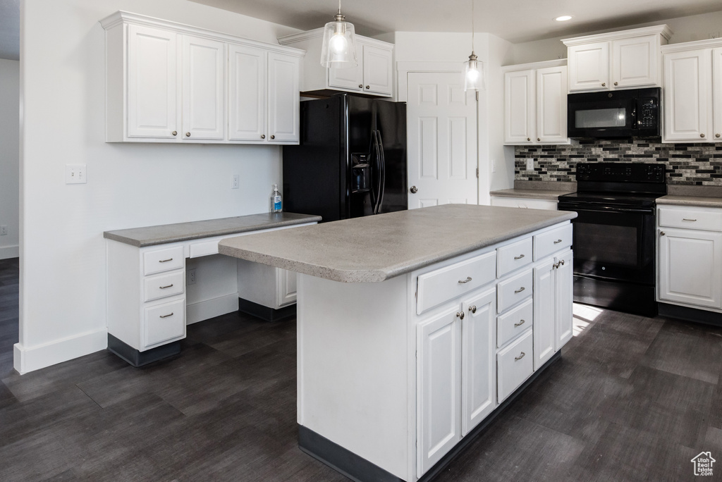 Kitchen featuring hanging light fixtures, black appliances, a center island, and white cabinetry