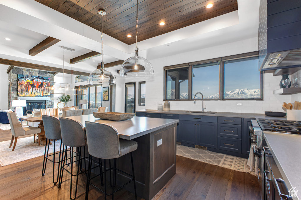 Kitchen with pendant lighting, dark wood-type flooring, a breakfast bar area, and sink