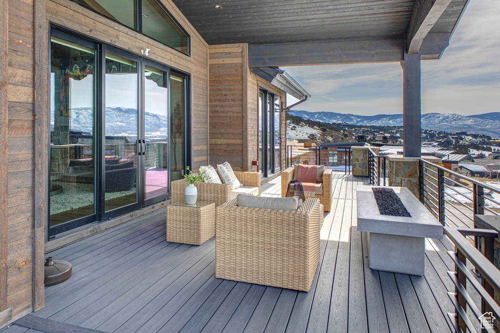 Wooden deck featuring an outdoor living space with a fire pit and a mountain view