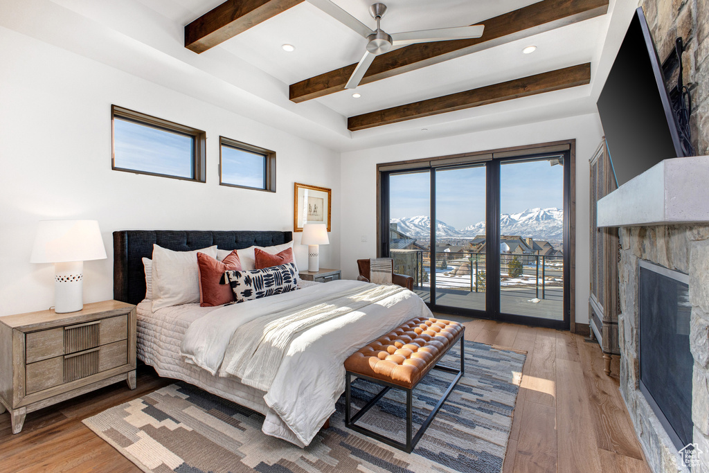 Bedroom featuring access to exterior, light hardwood / wood-style flooring, ceiling fan, and a mountain view