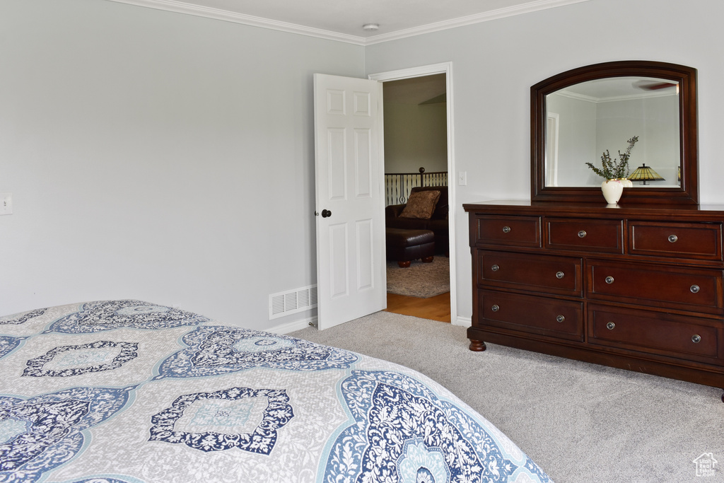 Carpeted bedroom with ornamental molding