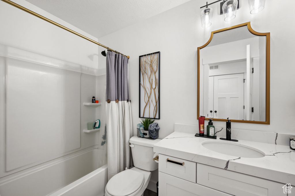 Full bathroom featuring toilet, oversized vanity, and shower / bath combo