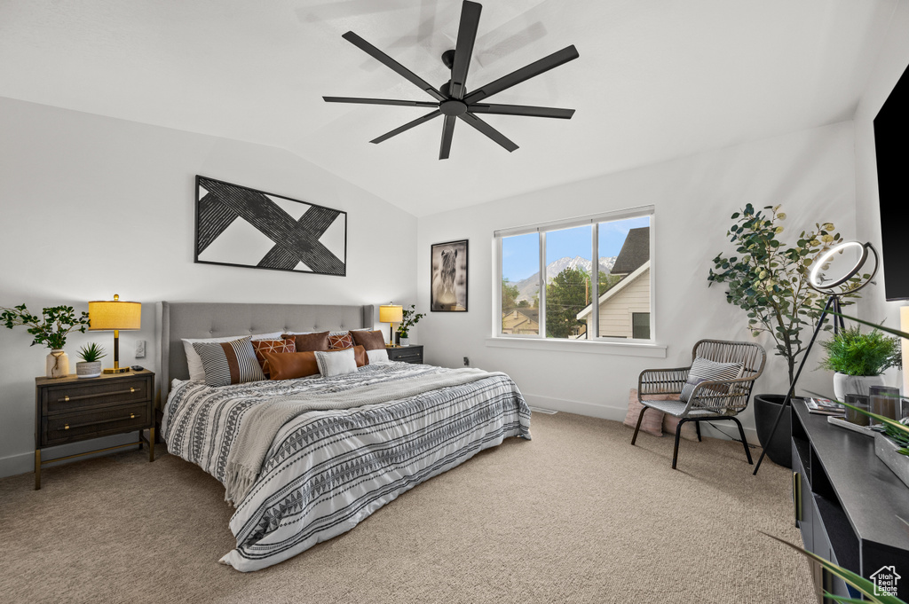 Bedroom with vaulted ceiling, light colored carpet, and ceiling fan