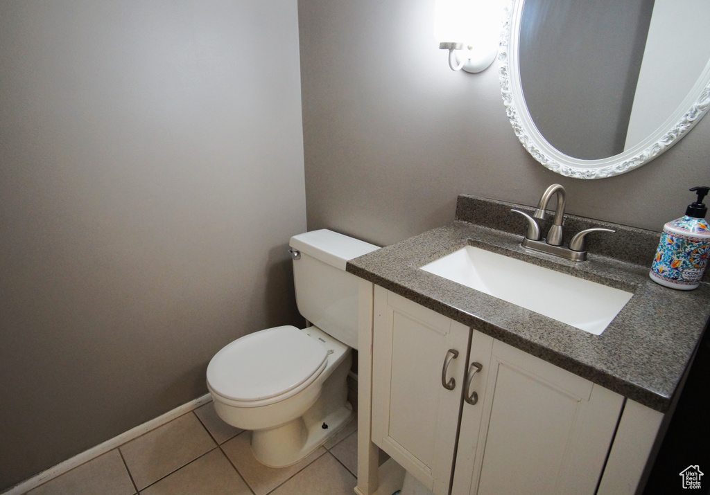 Bathroom with large vanity, tile flooring, and toilet