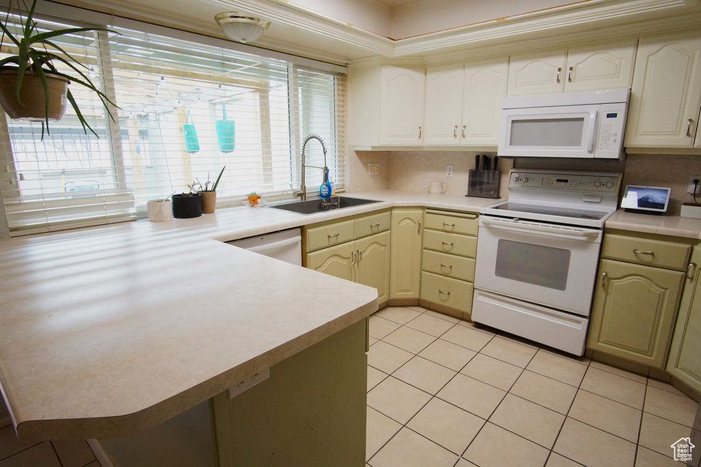 Kitchen featuring white appliances, light tile flooring, sink, and backsplash