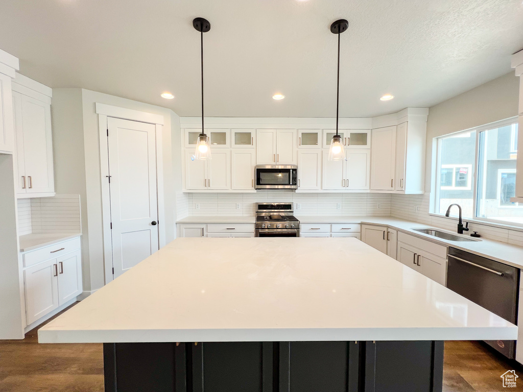 Kitchen featuring sink, a center island, stainless steel appliances, and pendant lighting