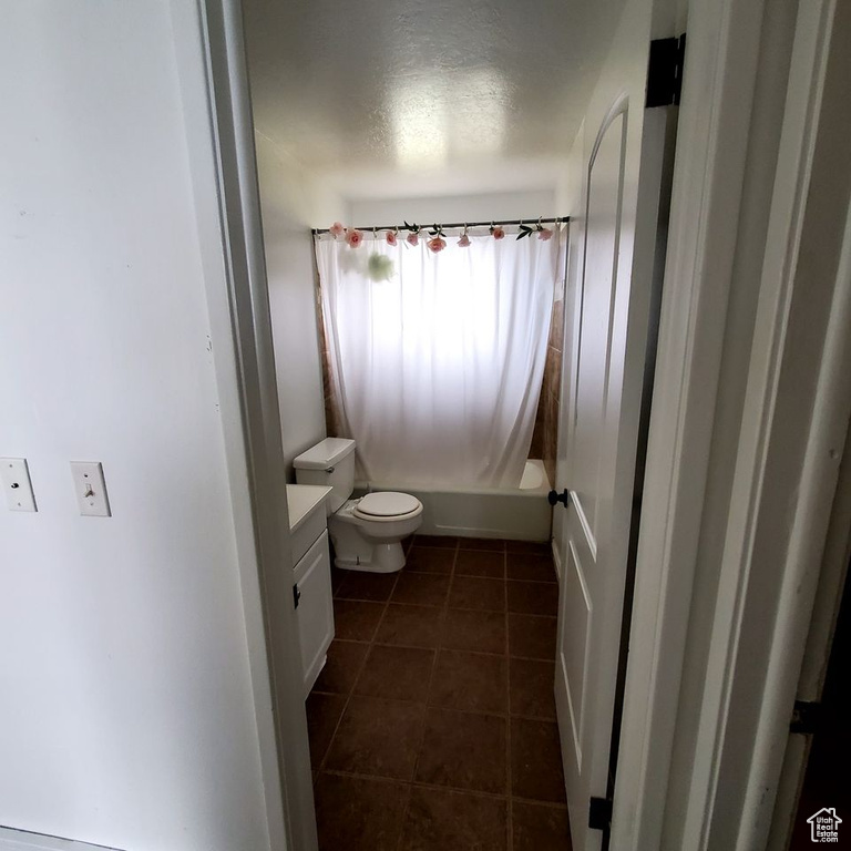 Bathroom with toilet, tile flooring, and vanity