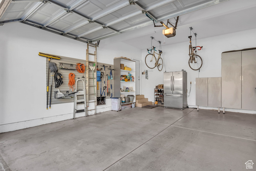 Garage with a garage door opener and stainless steel refrigerator