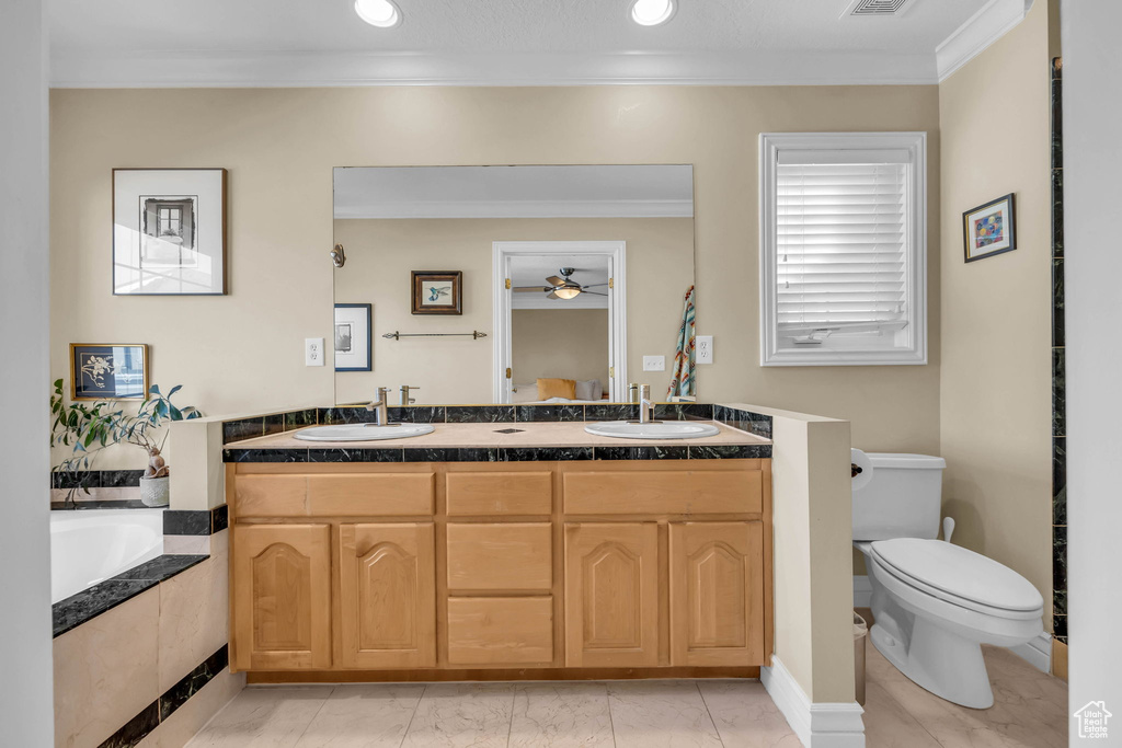 Bathroom featuring toilet, crown molding, dual bowl vanity, and tile flooring