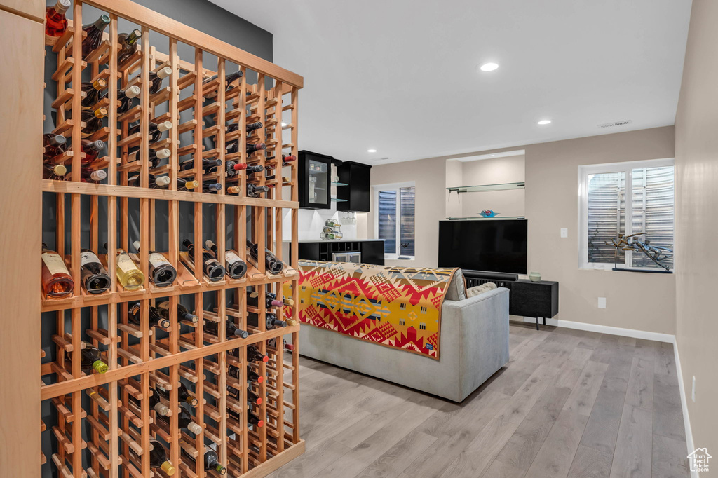 Wine room with light hardwood / wood-style flooring