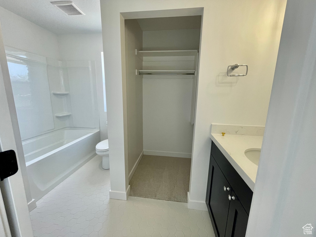 Full bathroom featuring vanity, tile floors, toilet, and shower / tub combination
