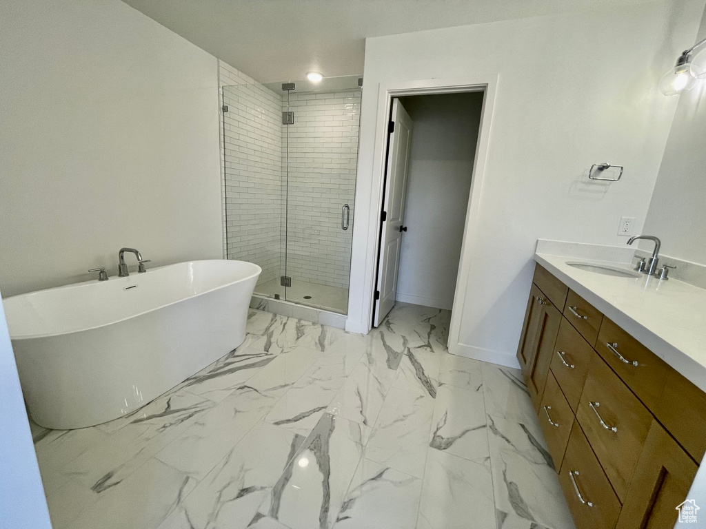Bathroom with tile flooring, vanity, and shower with separate bathtub