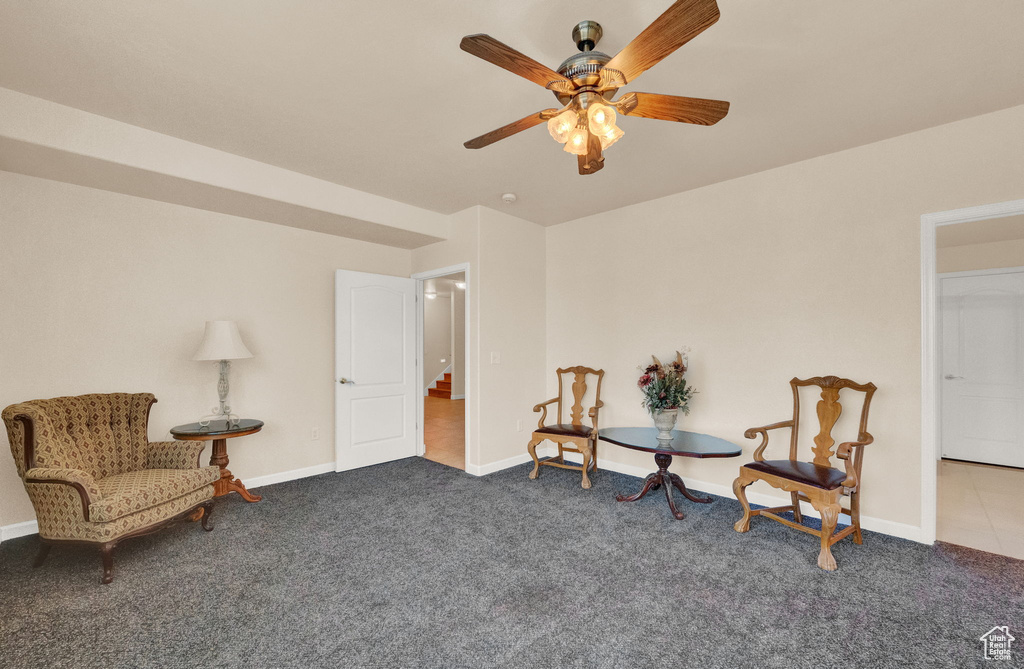 Living area featuring light colored carpet and ceiling fan