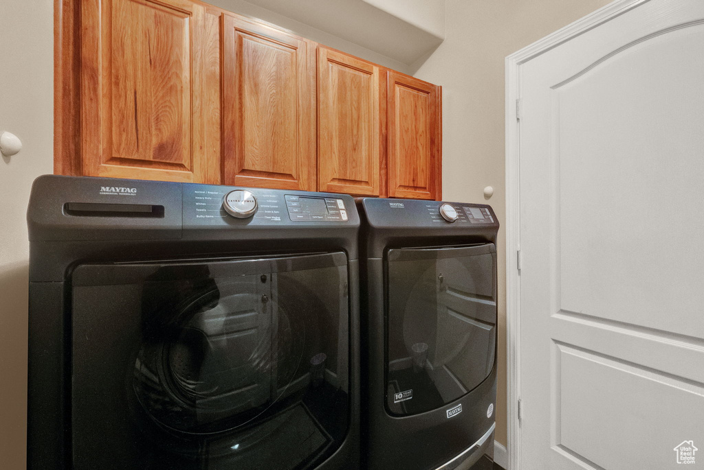 Laundry room with cabinets and washer and clothes dryer