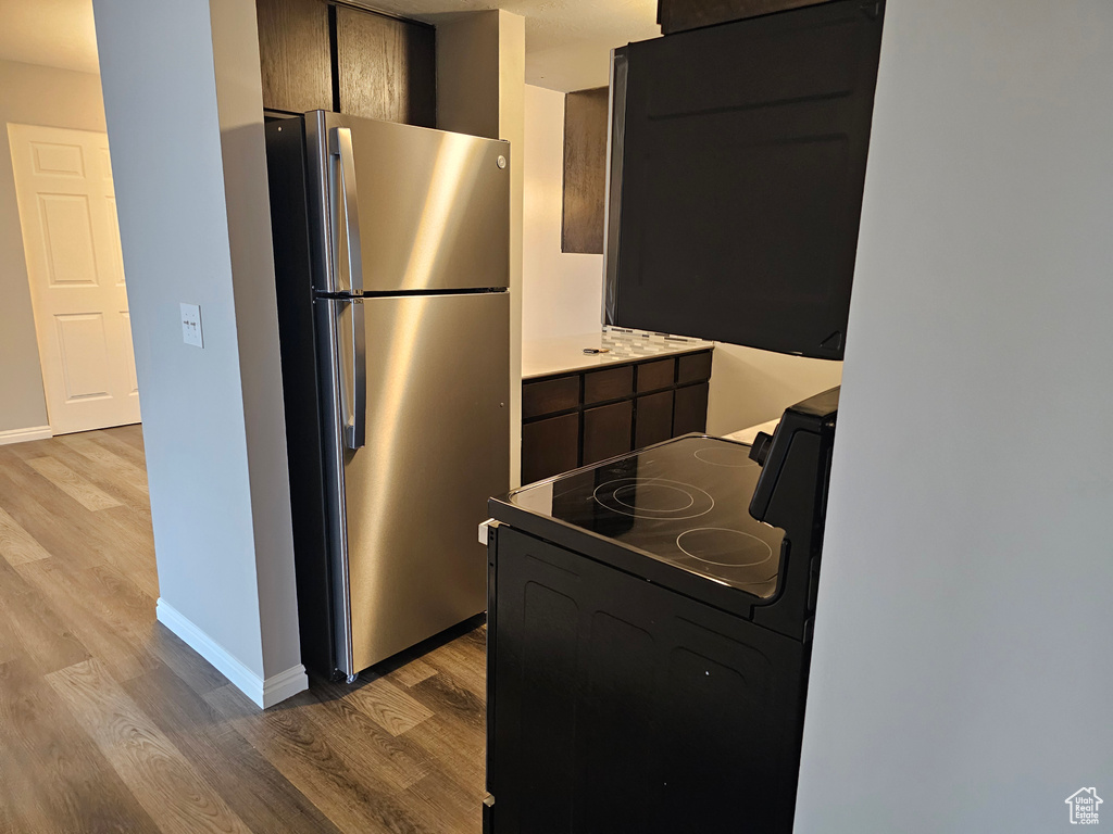 Kitchen with range, light hardwood / wood-style flooring, and stainless steel fridge
