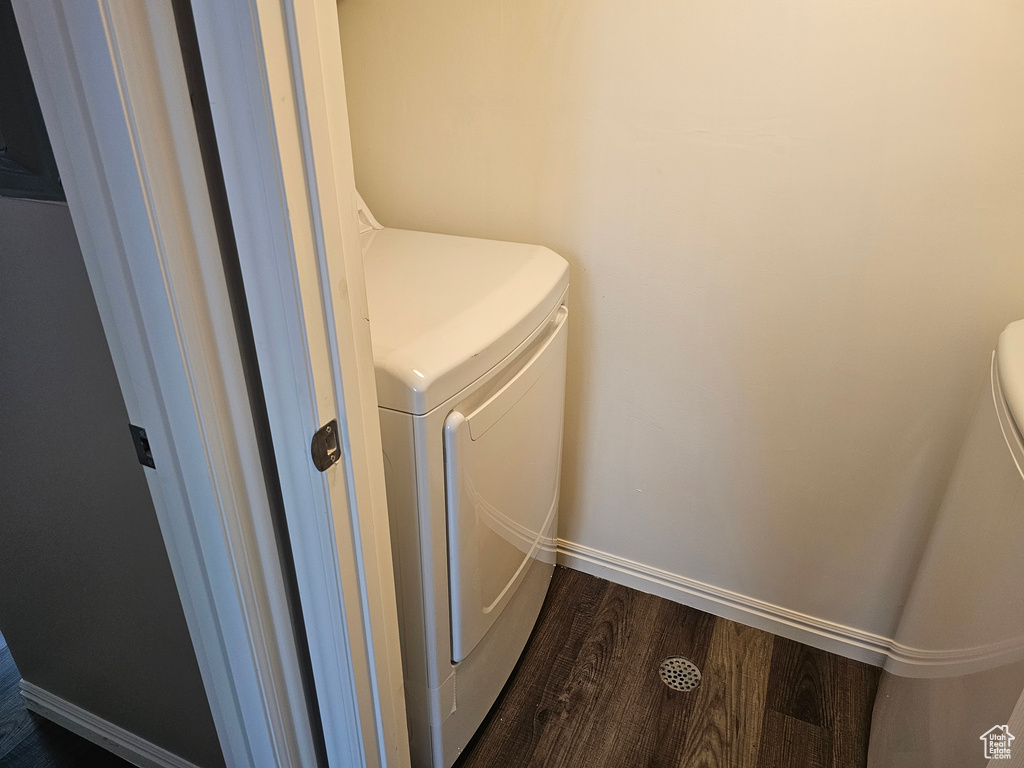 Washroom with washer and dryer and dark hardwood / wood-style floors