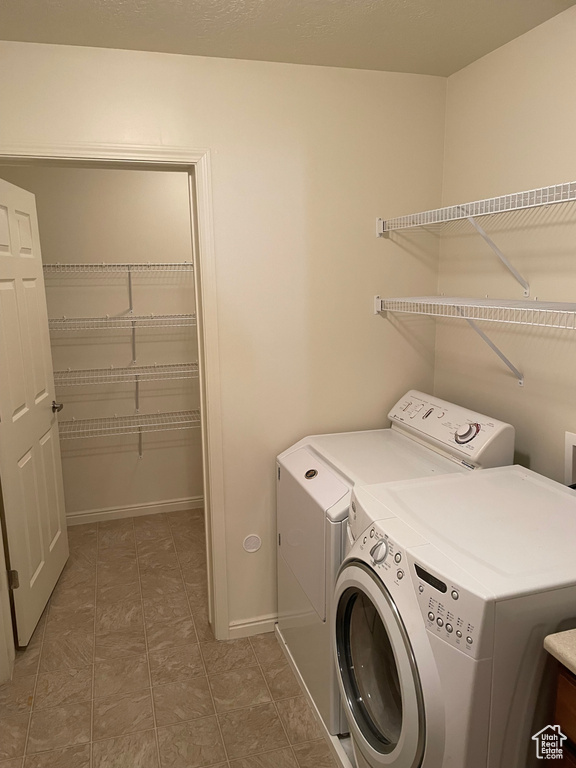 Laundry room with dark tile floors and independent washer and dryer