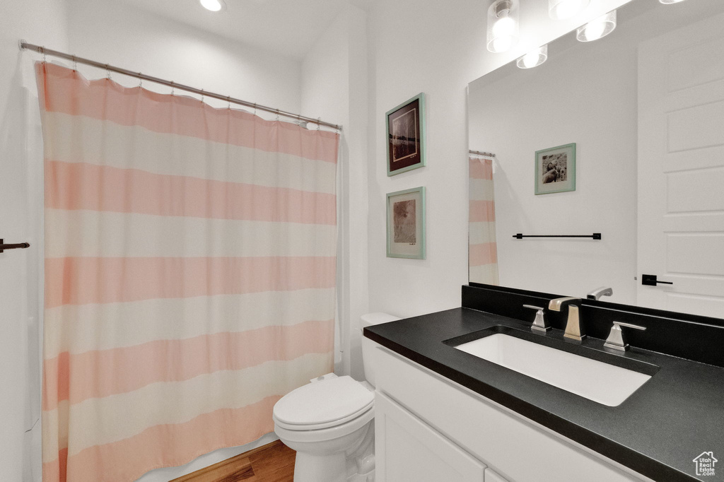 Bathroom featuring hardwood / wood-style floors, toilet, and oversized vanity