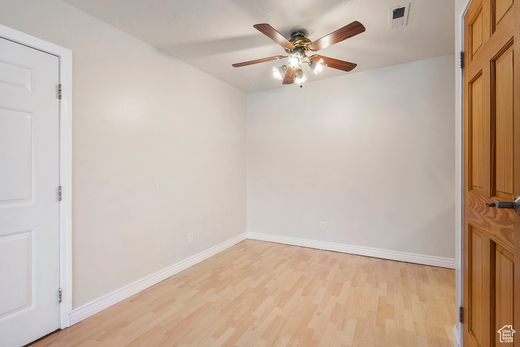 Empty room with light wood-type flooring and ceiling fan