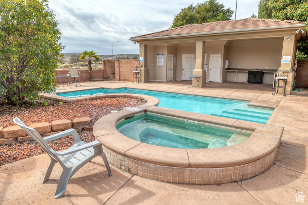 View of pool with an in ground hot tub and a patio area