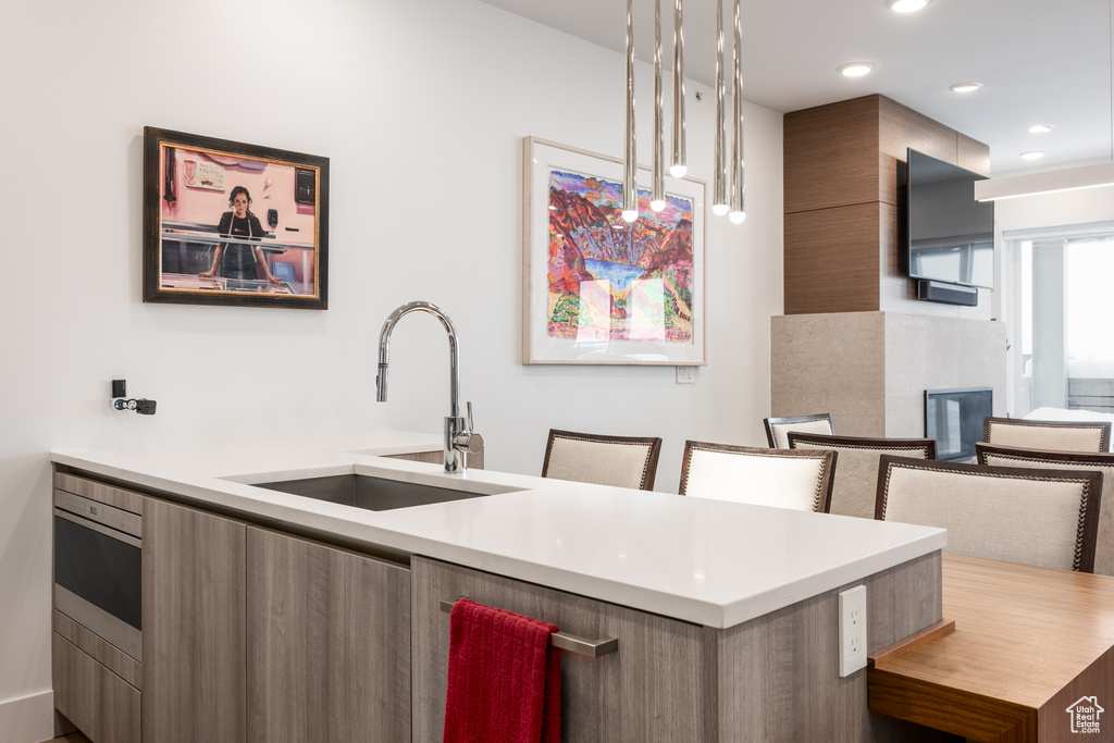 Kitchen featuring sink, pendant lighting, and a breakfast bar