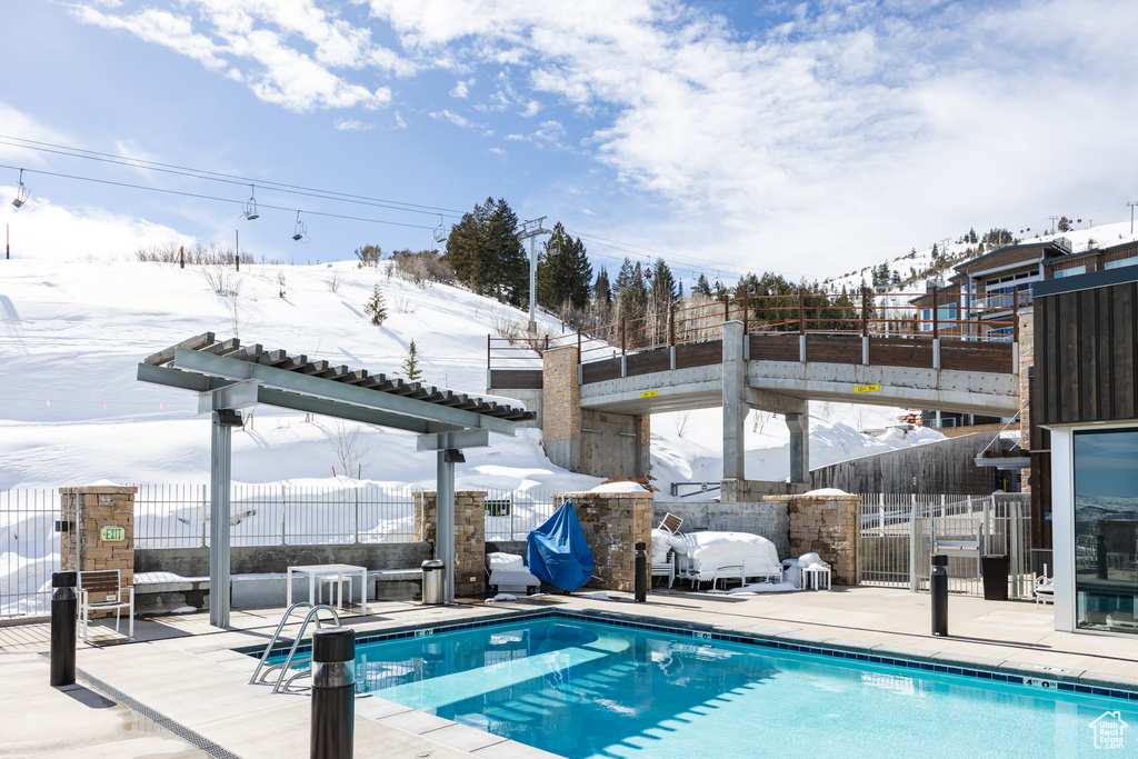 Snow covered pool featuring a patio
