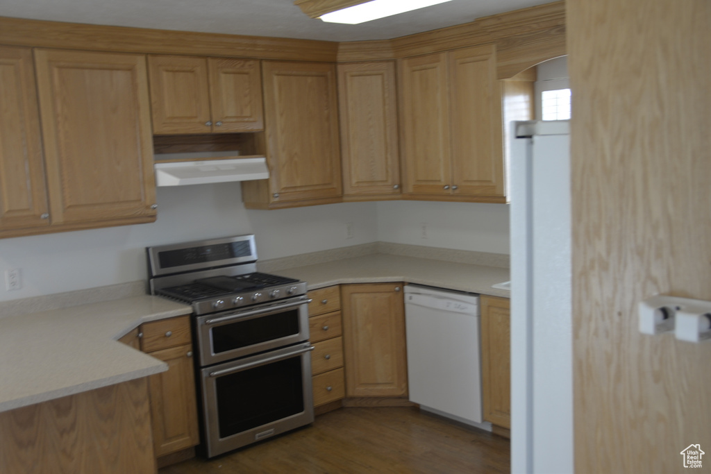 Kitchen featuring dark hardwood / wood-style floors, fridge, light brown cabinets, white dishwasher, and range with two ovens