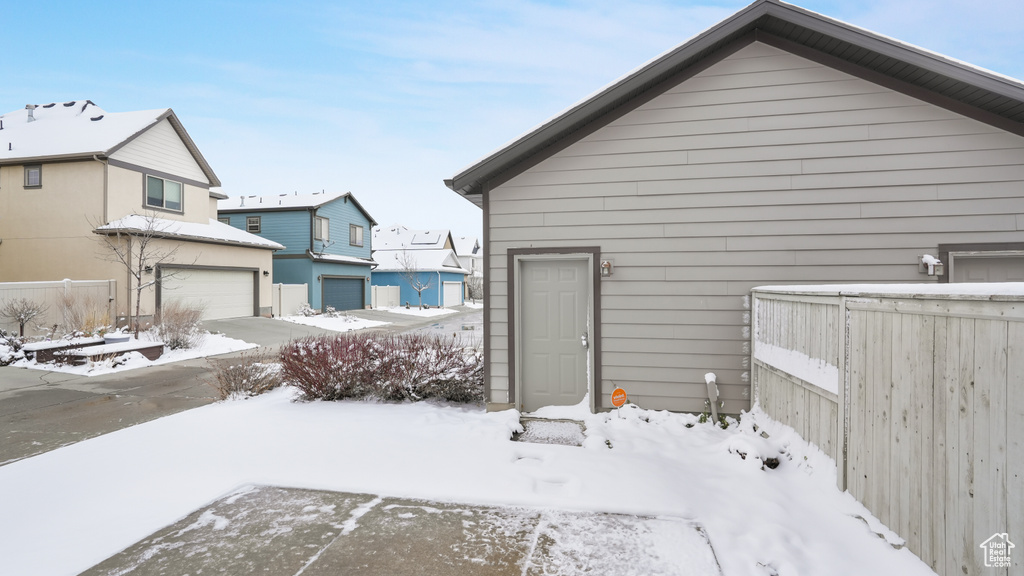 View of snow covered exterior with a garage