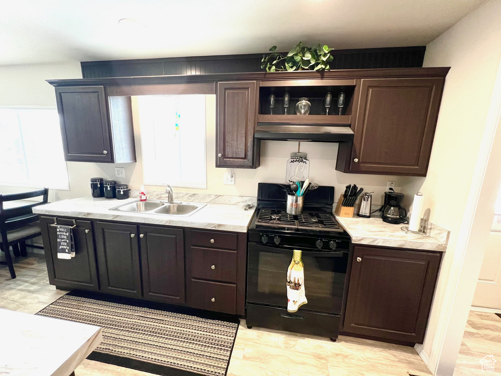 Kitchen with plenty of natural light, sink, black gas range, and dark brown cabinets