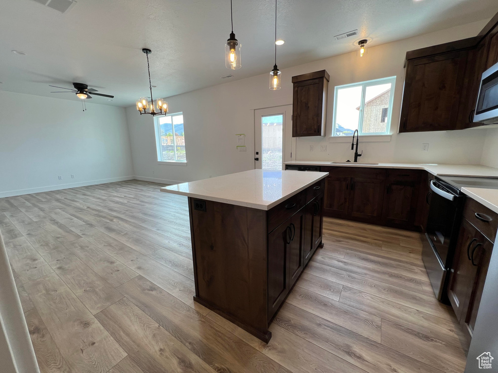 Kitchen featuring a wealth of natural light, pendant lighting, light hardwood / wood-style floors, and sink