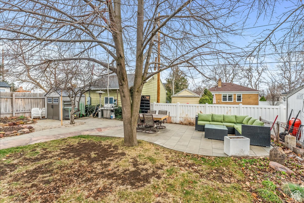 View of yard featuring a storage unit, a patio, and outdoor lounge area